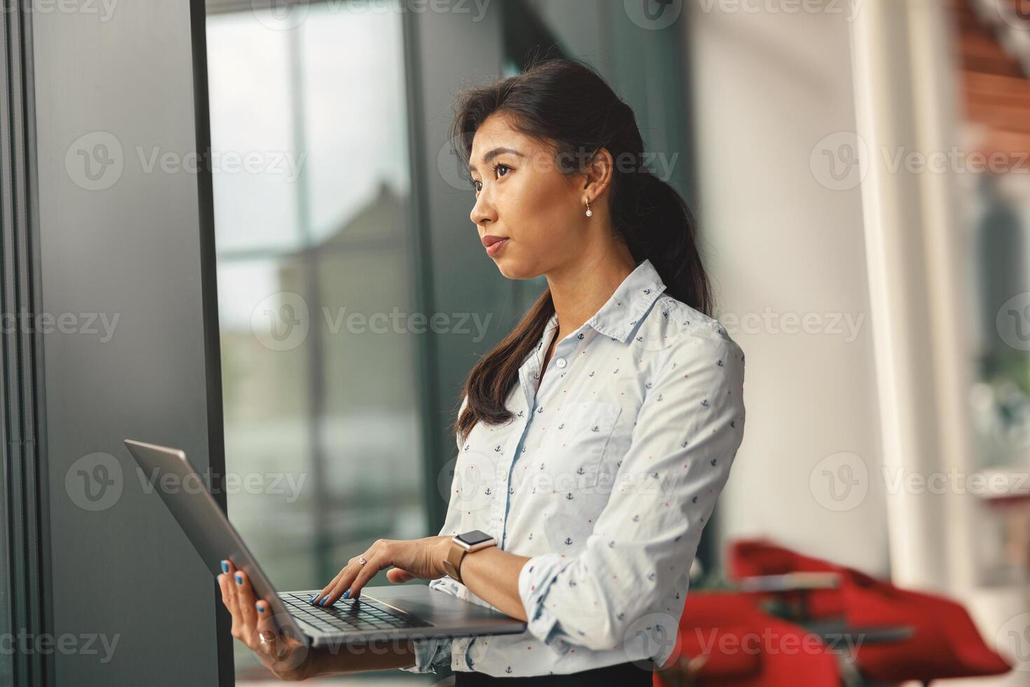 gefocust vrouw verkoop manager werken Aan laptop terwijl staand Aan coworking achtergrond foto