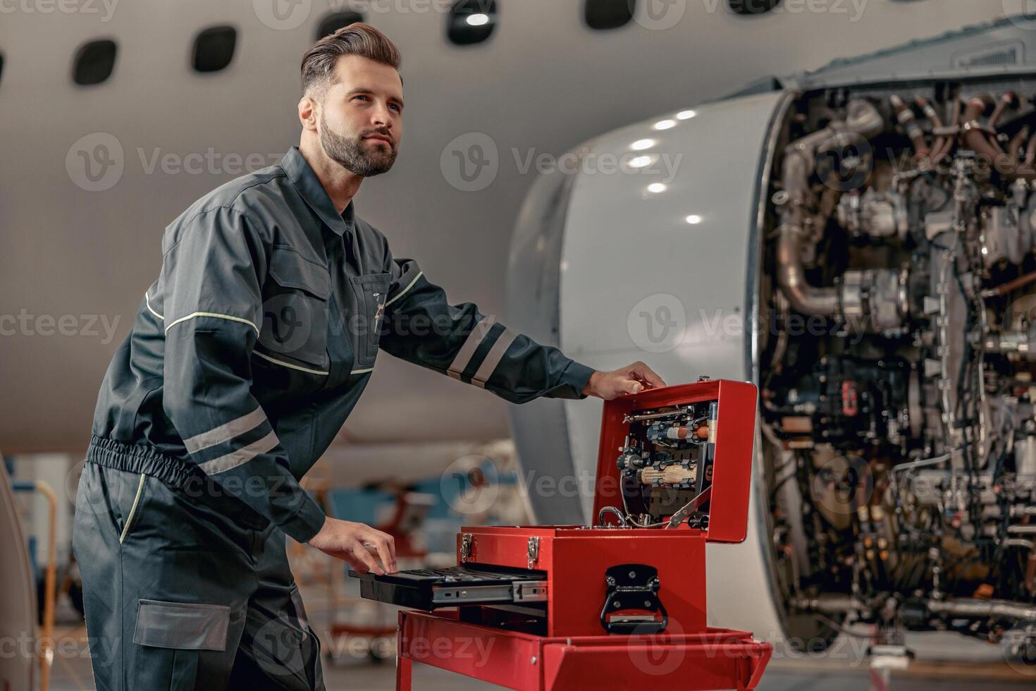 gebaard Mens vliegmaatschappij monteur werken in vliegtuig hangar foto