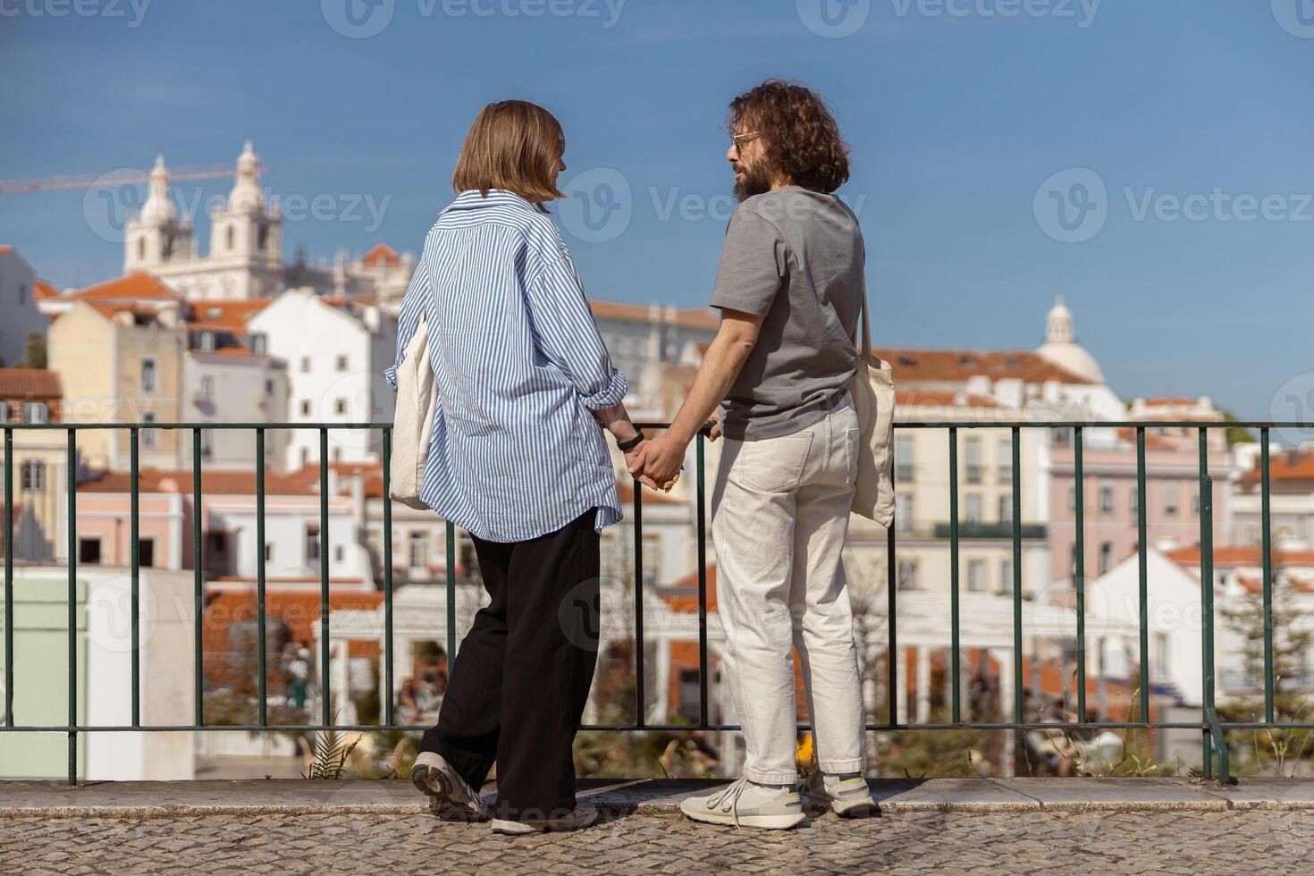 terug visie van romantisch hipster paar in liefde Holding handen terwijl wandelen Aan oud stad straat foto