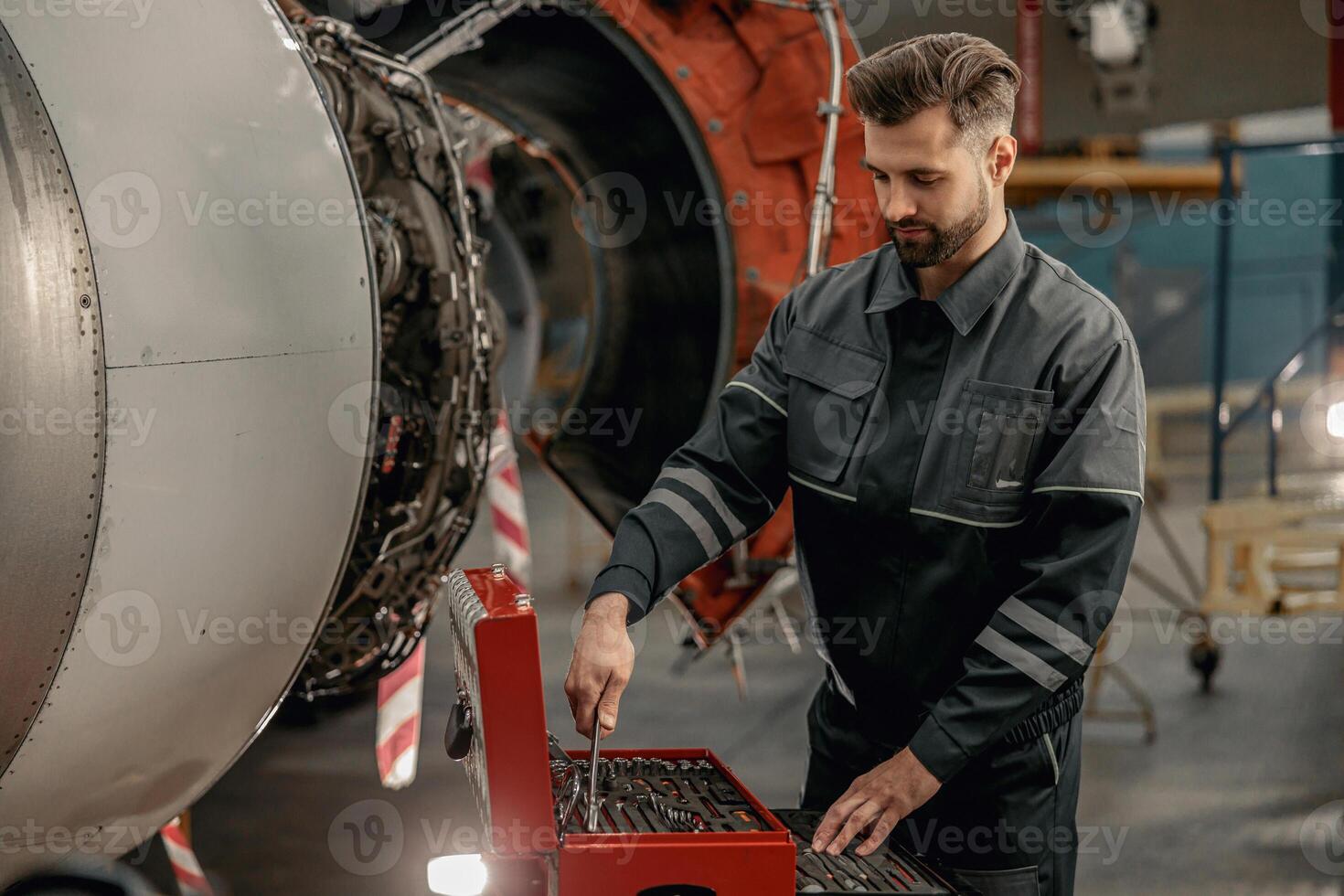 mannetje vliegtuig monteur gebruik makend van instrument doos in hangar foto