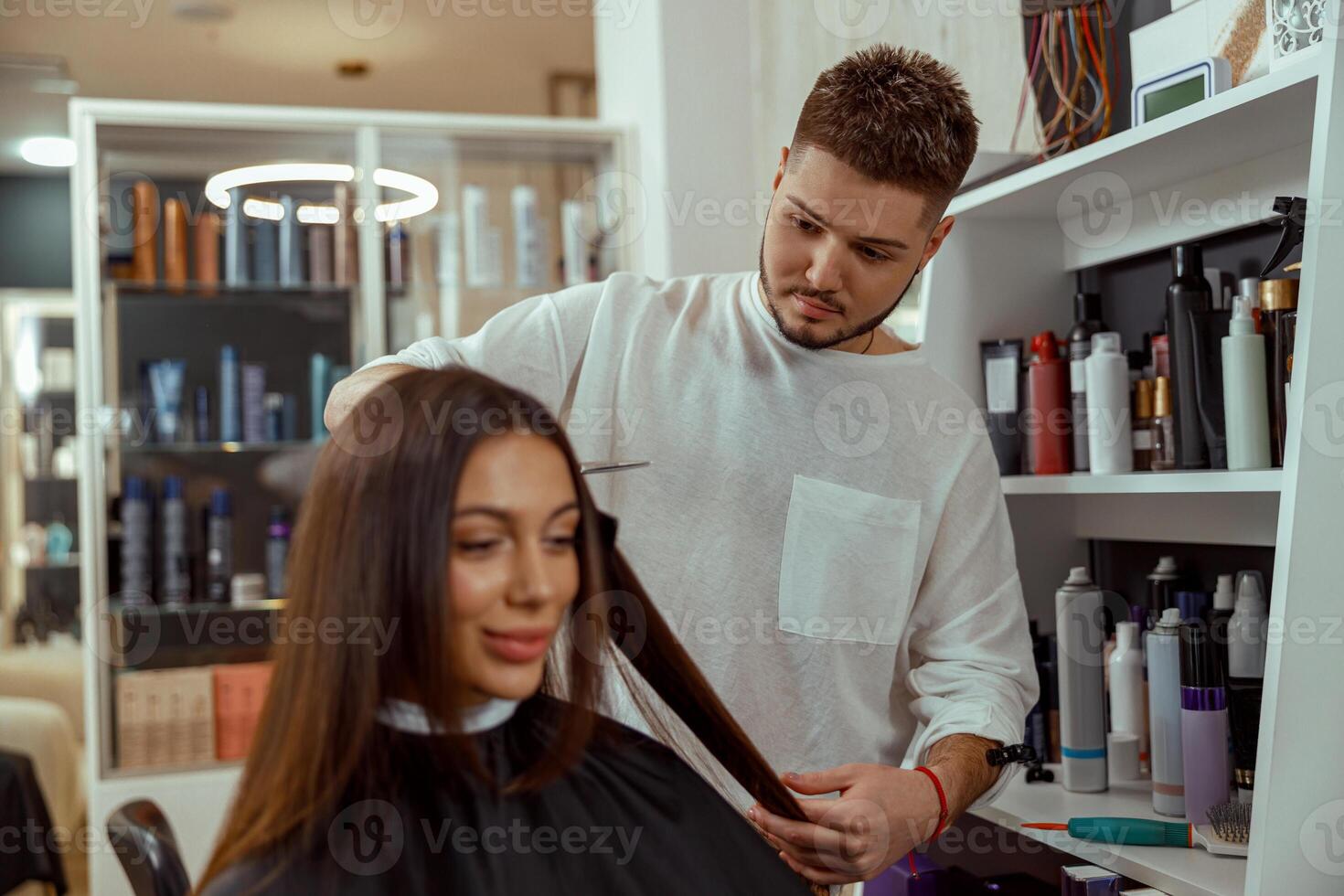 professioneel mannetje kapper snijdend haar- van vrouw Bij schoonheid salon foto