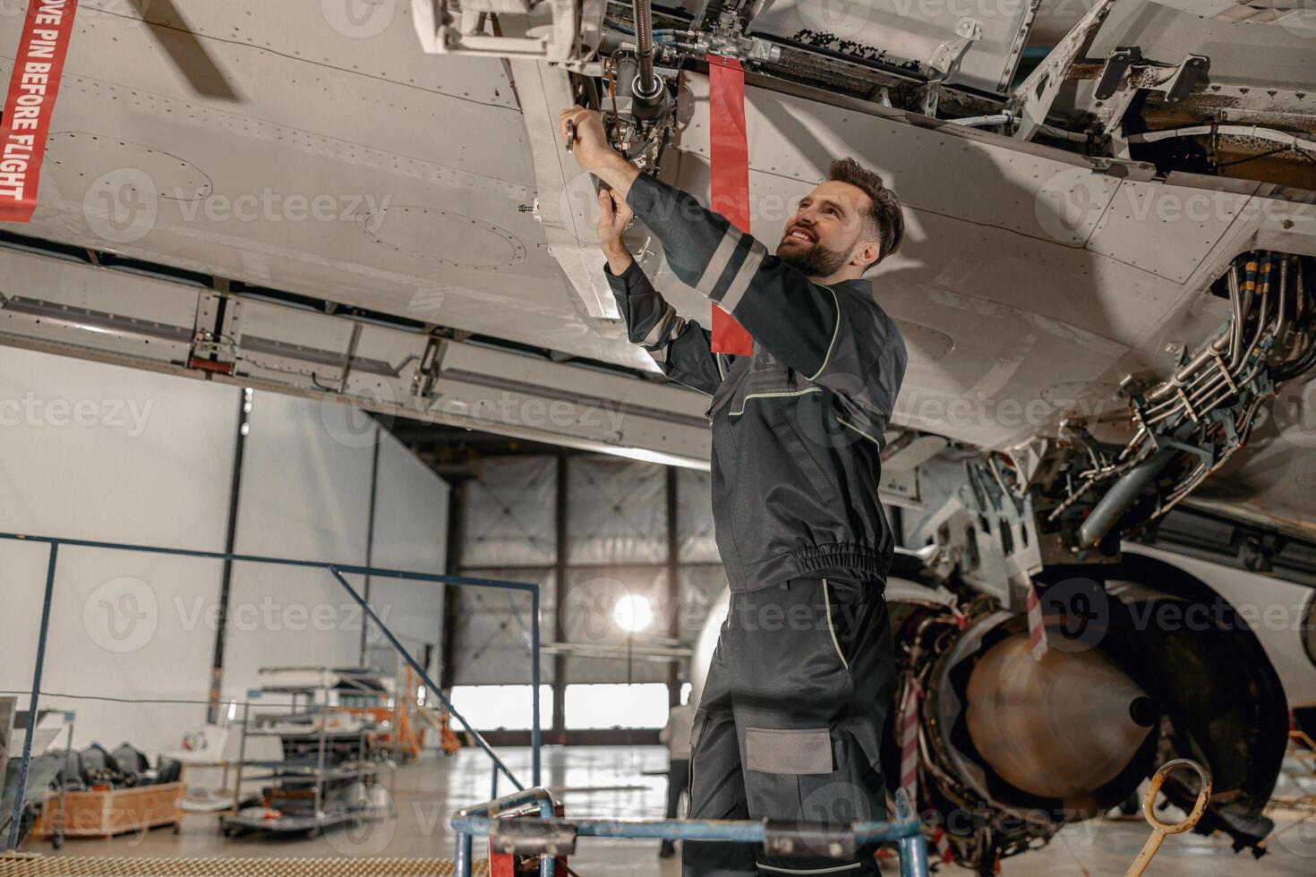 vrolijk mannetje monteur repareren vliegtuig Bij reparatie station foto