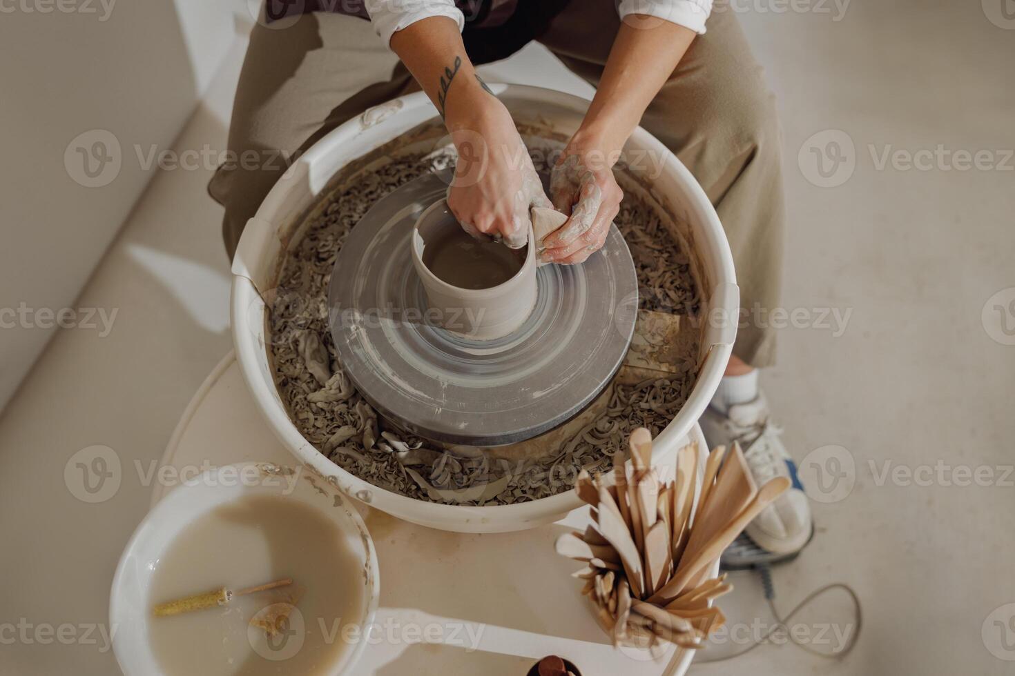 dichtbij omhoog van handen van professioneel pottenbakker gieten pot vorm Aan pottenbakkerij wiel. keramiek kunst concept foto