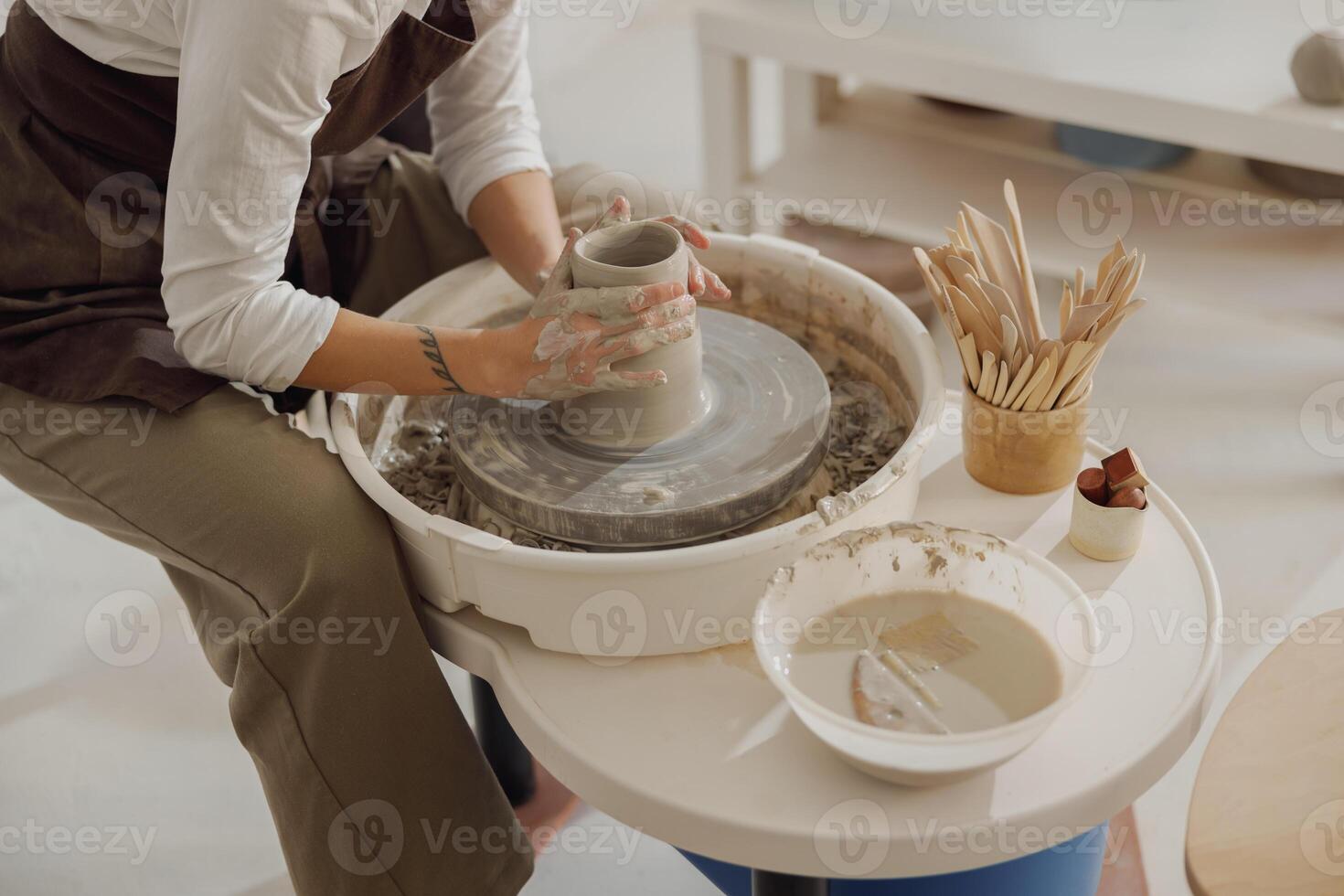 dichtbij omhoog van handen van professioneel pottenbakker gieten pot vorm Aan pottenbakkerij wiel. keramiek kunst concept foto