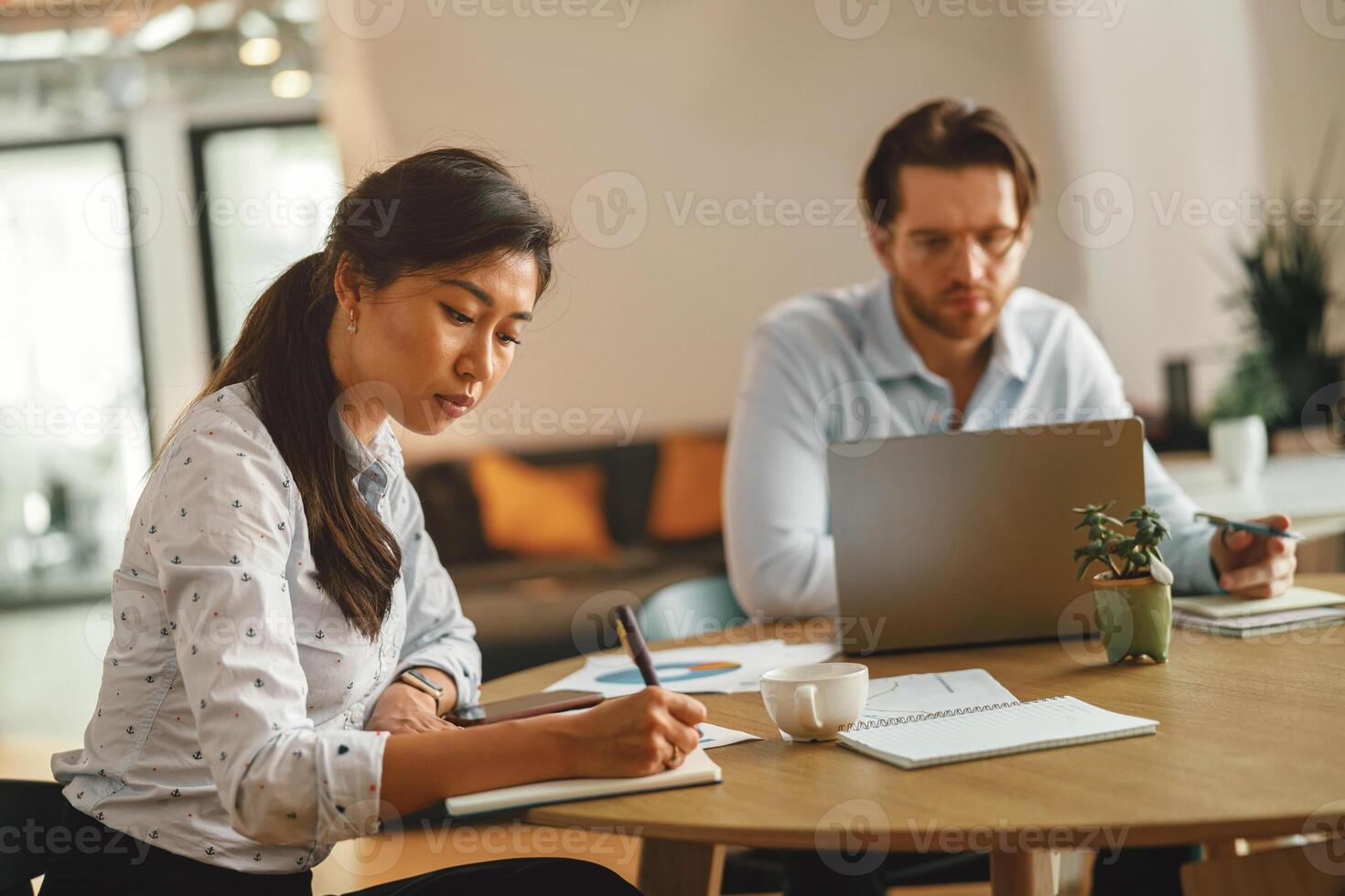 twee kantoor arbeiders werken Aan project terwijl zittend in modern samenwerken. hoog kwaliteit foto