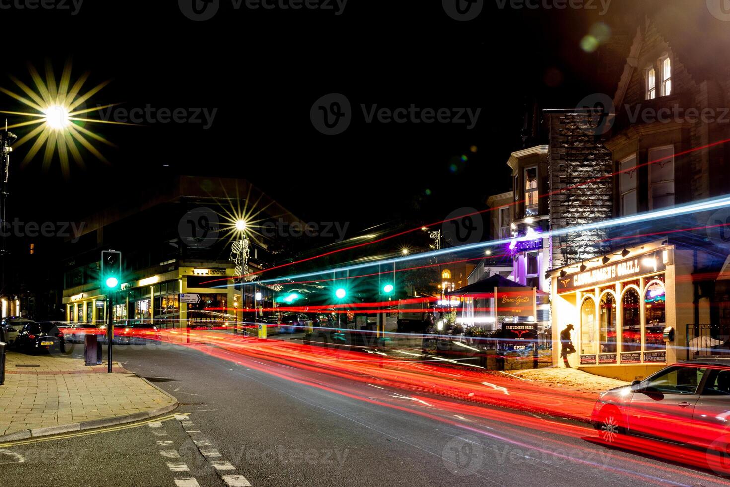 nacht stadsgezicht met licht trails van in beweging voertuigen Aan een bruisend straat, presentatie van stedelijk nachtleven en beweging in harrogeren, noorden yorkshire, uk. foto