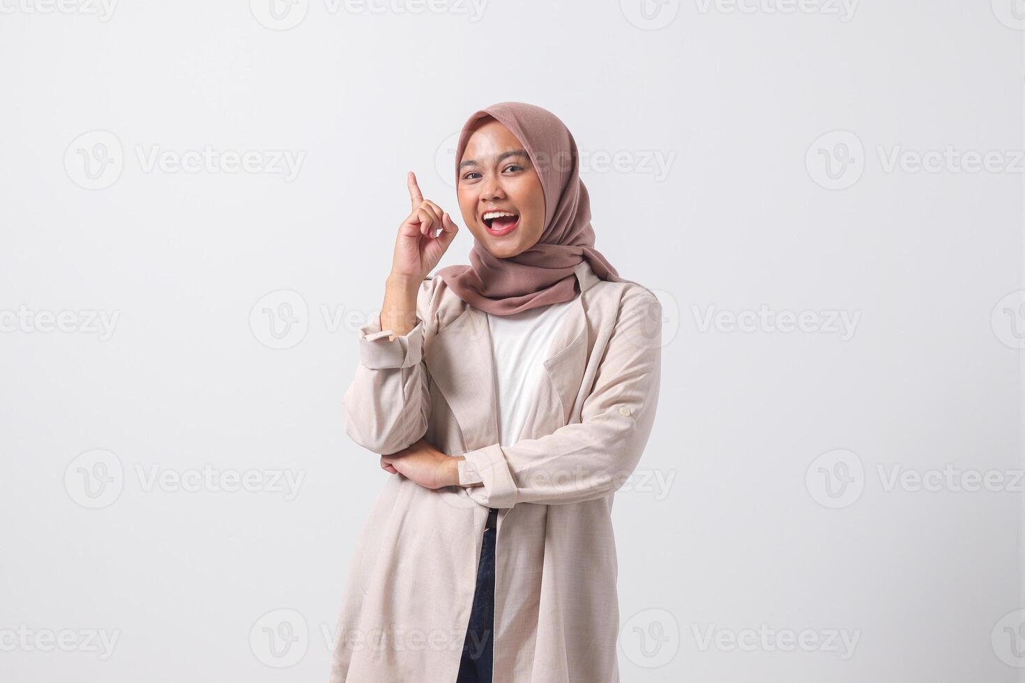 portret van opgewonden Aziatisch hijab vrouw in gewoontjes pak richten omhoog haar wijsvinger en herinneren iets naar doen. zakenvrouw concept. geïsoleerd beeld Aan wit achtergrond foto