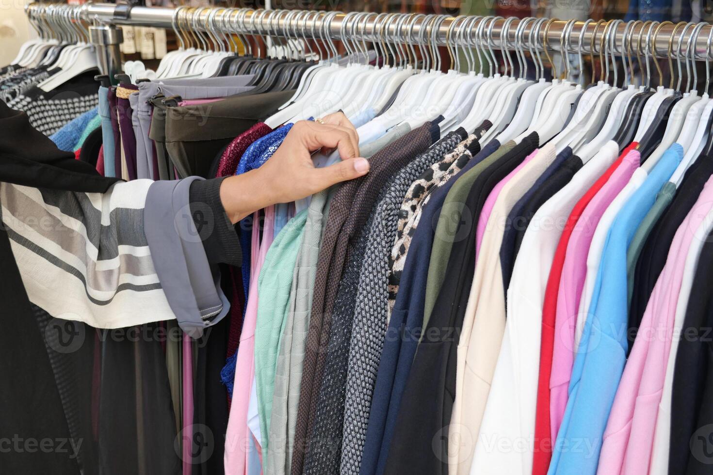 vrouw kiezen kleren in winkel. foto