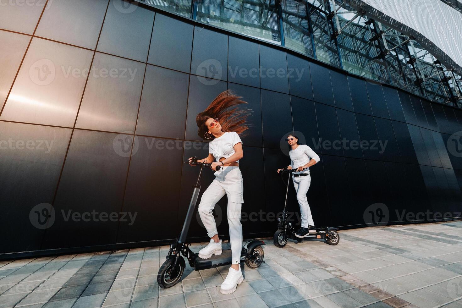 een meisje en een vent zijn wandelen Aan elektrisch scooters in de omgeving van de stad, een paar in liefde Aan scooters. foto