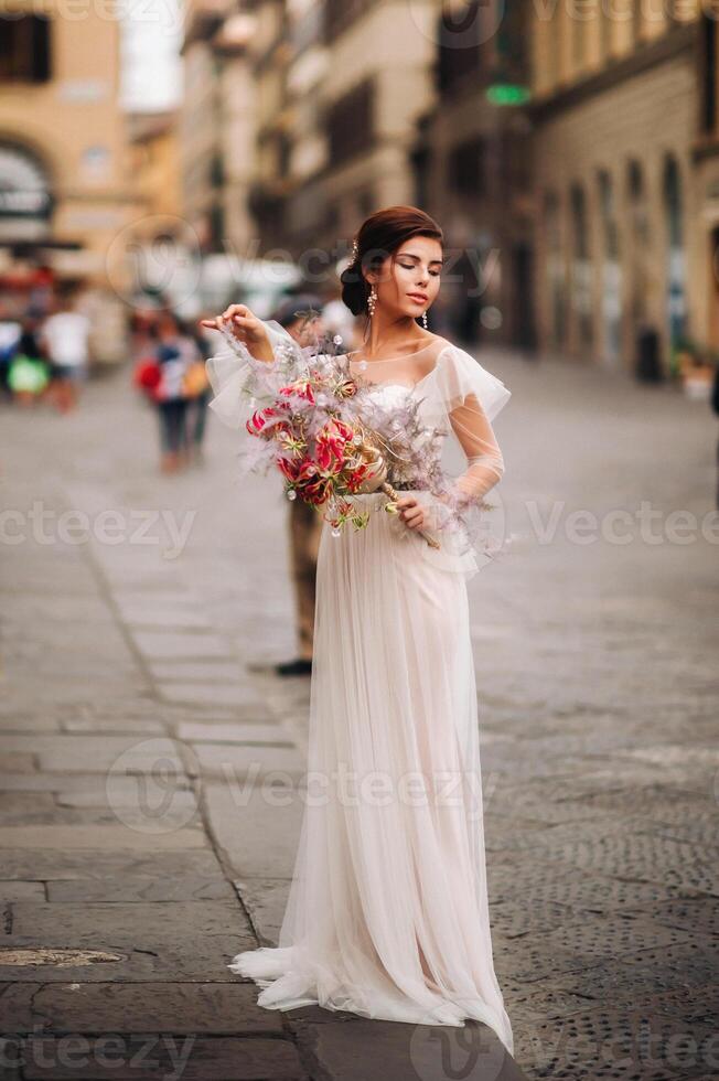 de meisje-bruid is met mooi bloem patroon net zo een masker in Florence, elegant bruid in een bruiloft jurk staand met een masker in de oud stad- van Florence. model- meisje in Florence foto