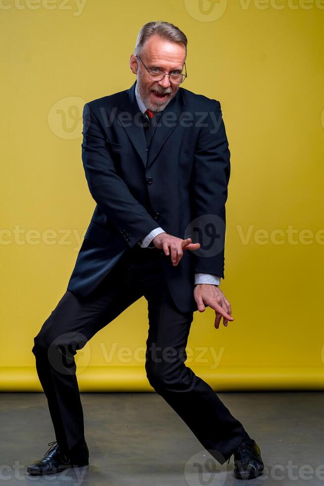 senior manager Mens dansen Bij grappig houding met uitdrukking. geel achtergrond. foto
