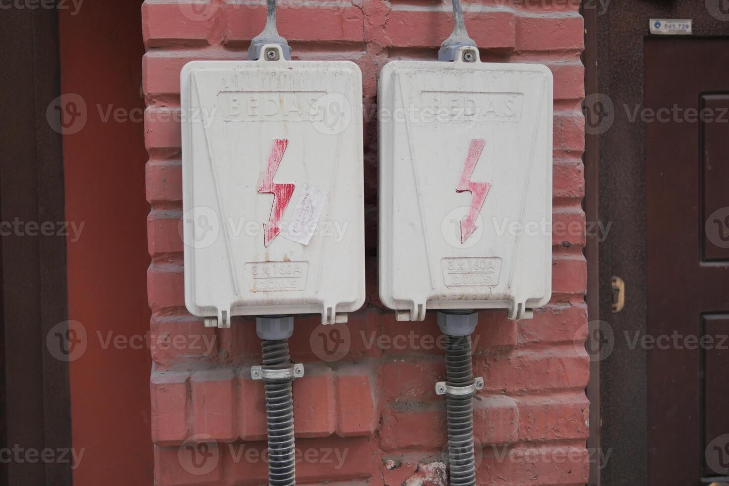 twee elektrisch dozen met bliksem bout Aan steen muur foto