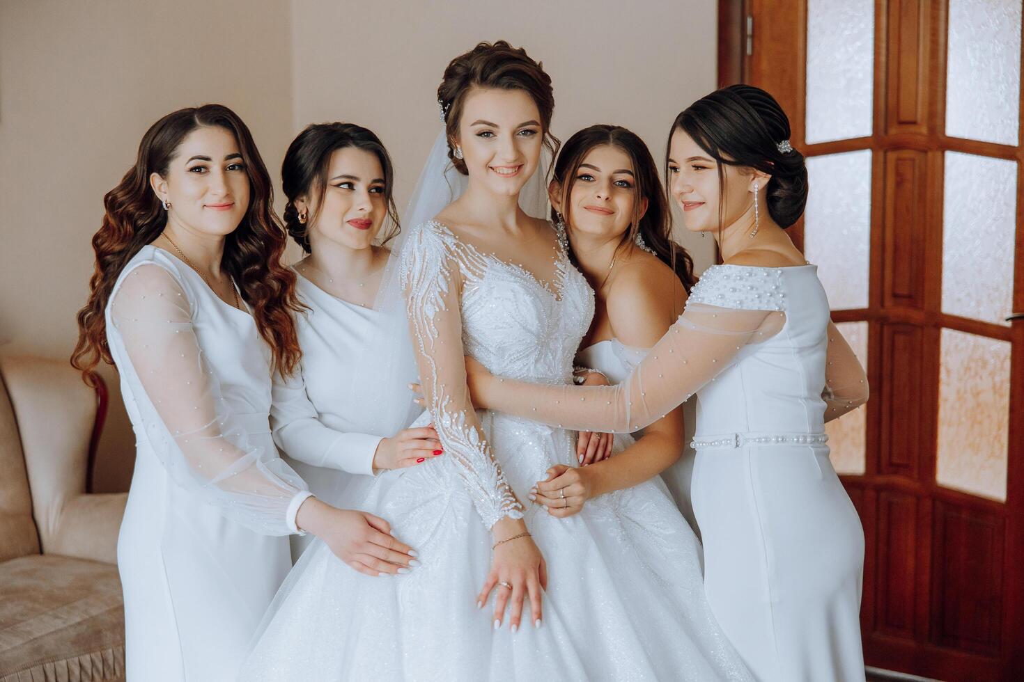 portret van de bruid met haar vrienden. elegant en elegant bruid met haar vrienden in bij elkaar passen jurken in de kamer in de ochtend. veel mooi meisjes in een foto. foto