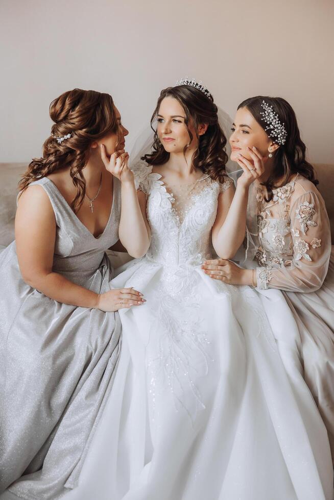 portret van de bruid met haar vrienden. elegant en elegant bruid met haar vrienden in bij elkaar passen jurken in de kamer in de ochtend. veel mooi meisjes in een foto. foto