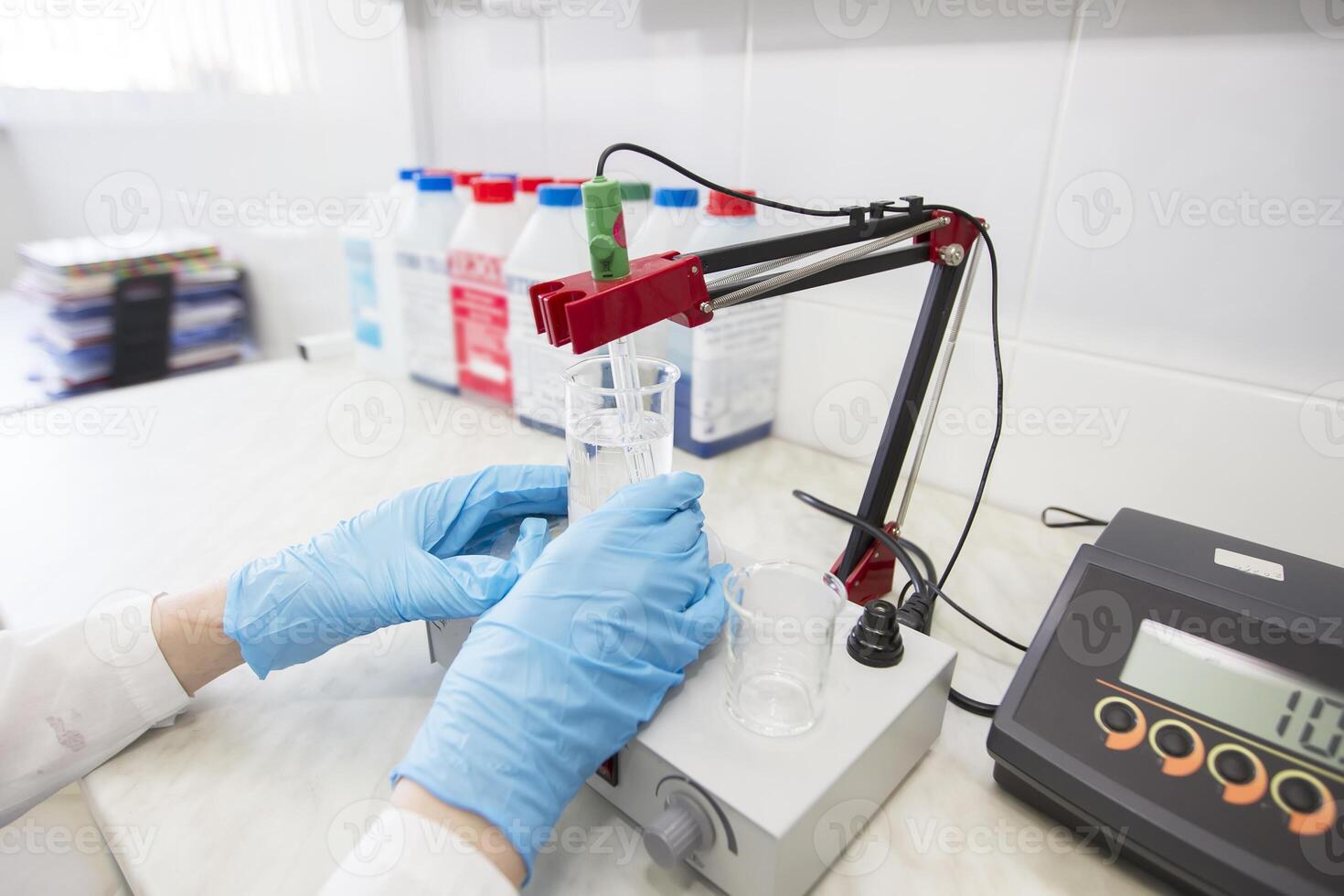 de handen van een technicus in blauw rubber handschoenen zijn Holding een fles. farmaceutisch industrie. chemisch laboratorium foto