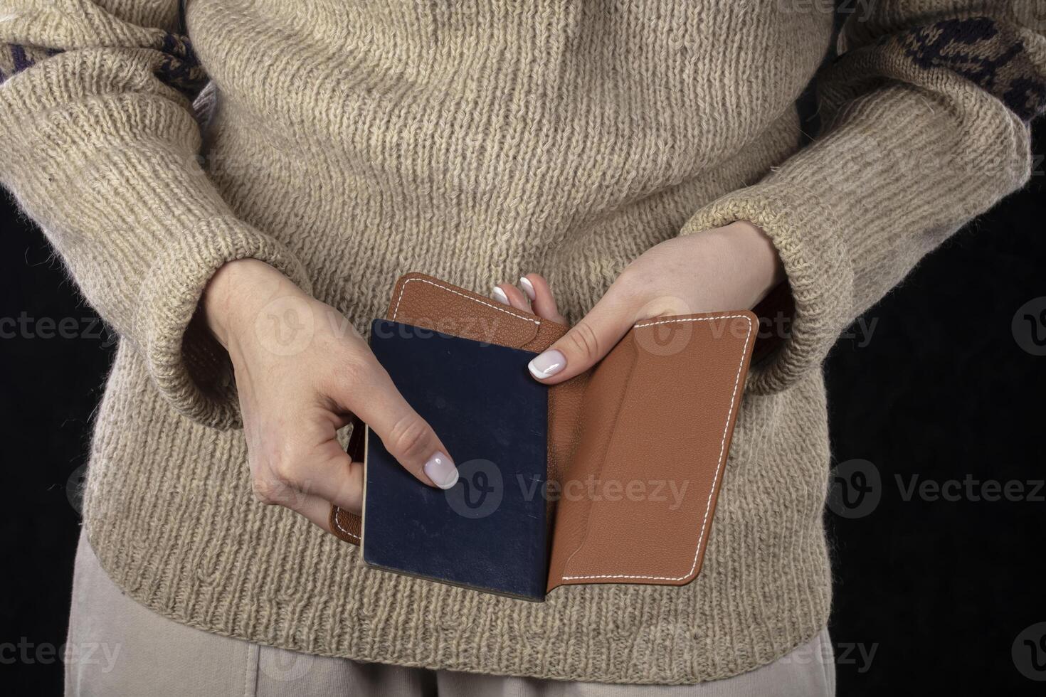 in vrouw handen Daar is een bruin handtas en een paspoort. foto