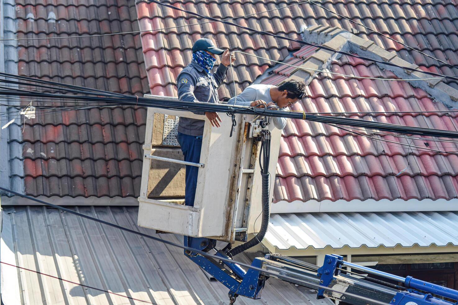 de openbaar werken afdeling is organiserende rommelig telecommunicatie en elektrisch kabels gebruik makend van een lucht optillen auto, Indonesië, 19 december 2023. foto