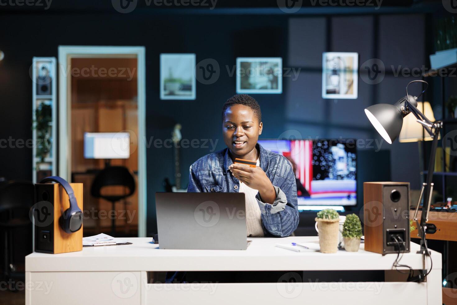 vrouw freelancer omarmt de digitaal leeftijd net zo ze looks voor producten online, gebruik maken van haar persoonlijk computer. jong zwart vrouw grijpen debiteren kaart uitgeven geld Aan e handel platformen. foto