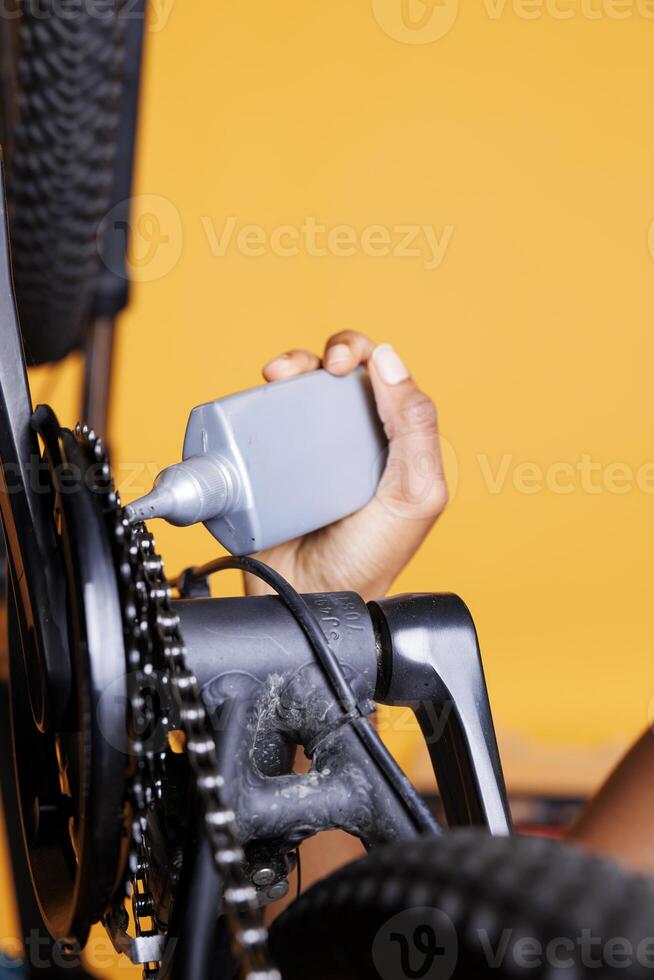 detailopname schot vitrines vrouw hand- Holding fiets olie voor zorgen voor magnifiek onderhoud en glad rijden. gedetailleerd visie van fiets keten wezen gesmeerd met vet voor veilig vrije tijd wielersport. foto