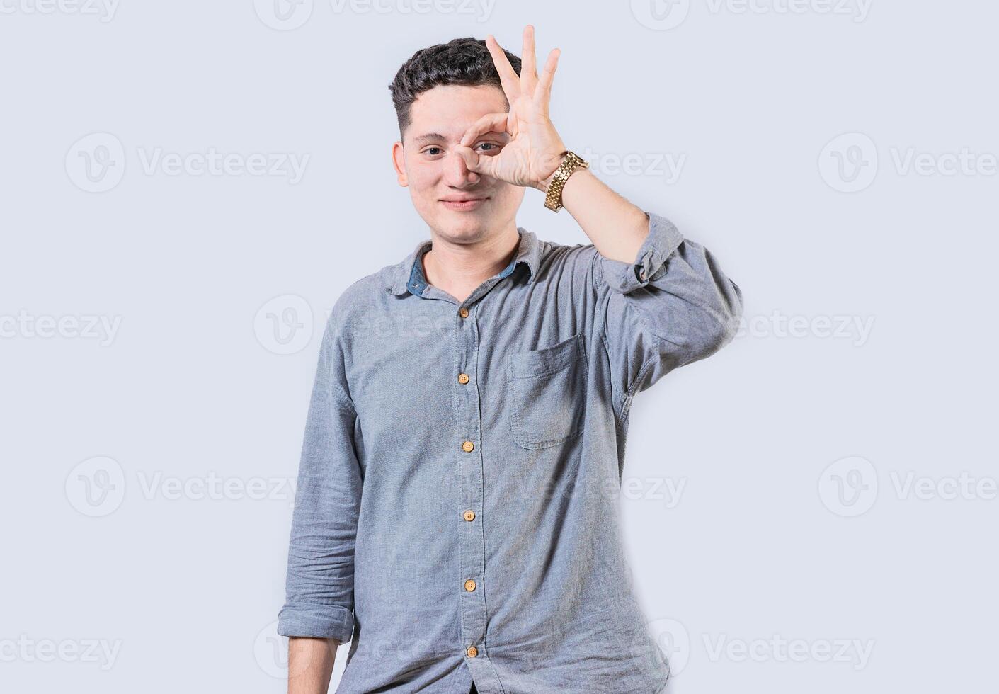 glimlachen persoon maken OK gebaar op zoek door vingers geïsoleerd. gelukkig jong Mens maken OK gebaar met hand- op zoek door vingers foto