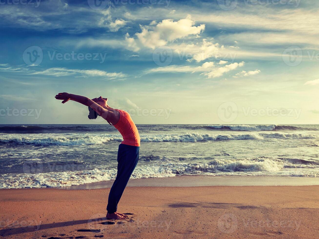 jong sportief fit vrouw aan het doen yoga zon begroeting surya namaskar foto