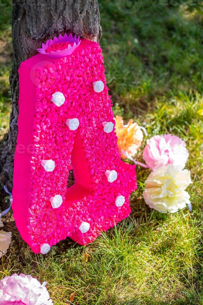 schattig handgemaakt decoratie voor verjaardag feest. groot papier aantal vier met bloemen in de park. foto