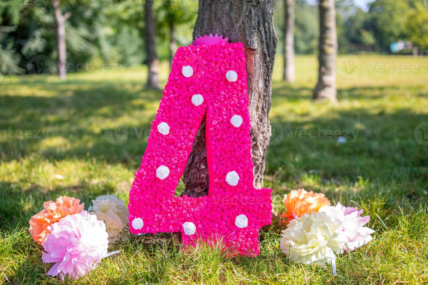 schattig handgemaakt decoratie voor verjaardag feest. groot papier aantal vier met bloemen in de park. foto