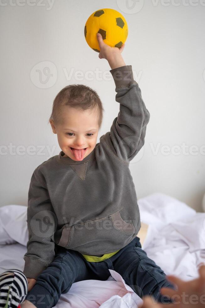 portret van klein jongen met naar beneden syndroom spelen met speelgoed- in huis slaapkamer. hoog kwaliteit foto