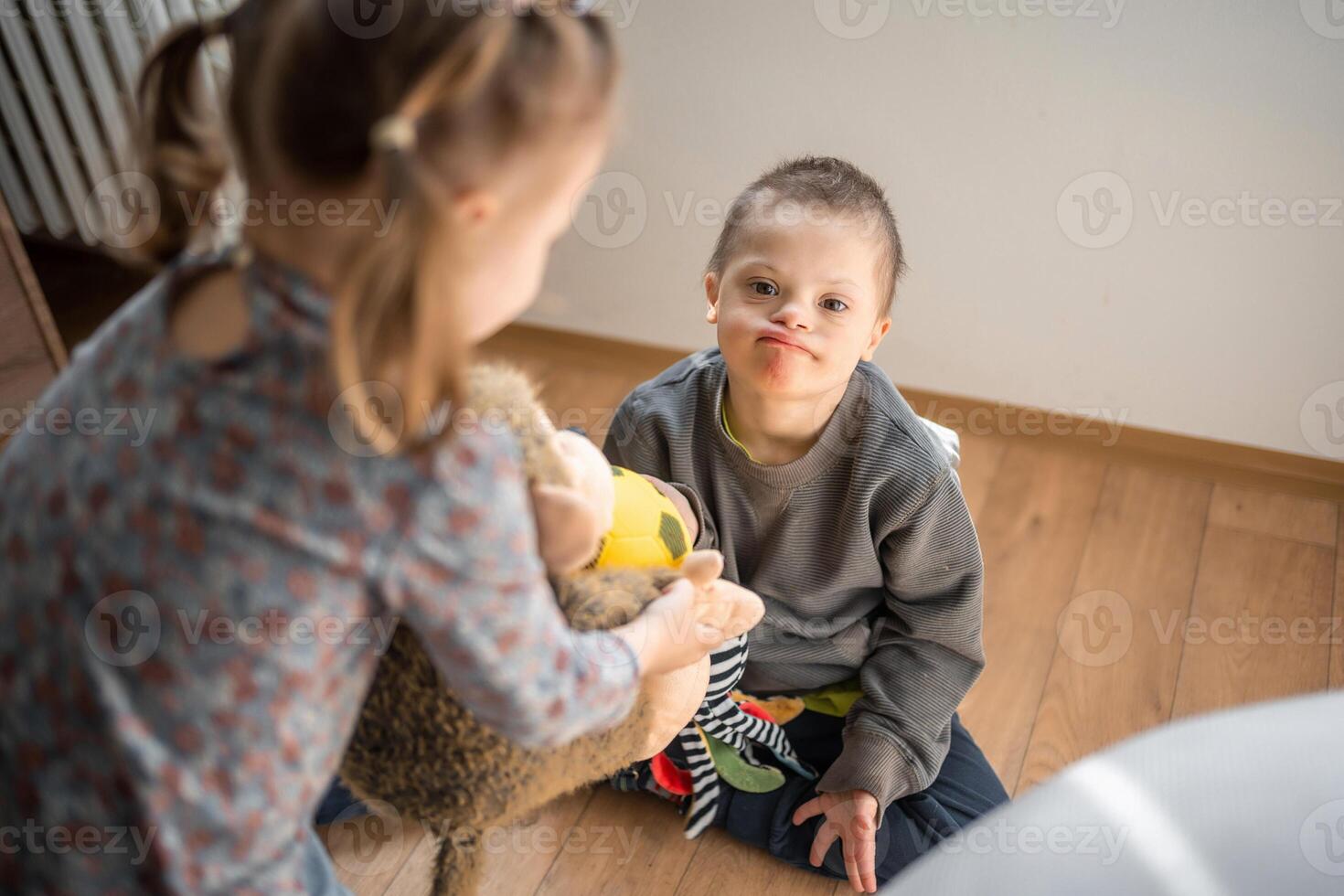 klein jongen met naar beneden syndroom Toneelstukken met zijn jonger zus in huis slaapkamer. hoog kwaliteit foto