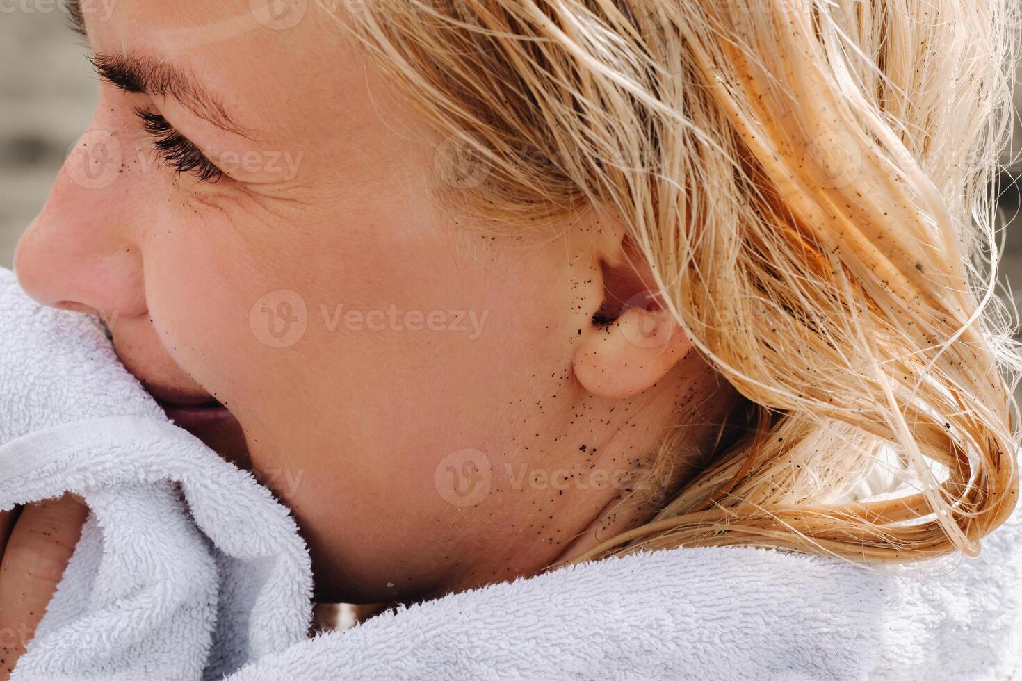 detailopname van een vrouw gezicht besmeurd in vulkanisch zwart zand Aan de strand foto