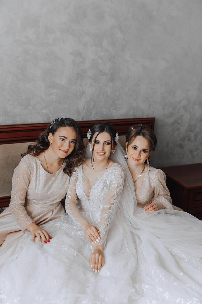 portret van de bruid met haar vrienden. elegant en elegant bruid met haar vrienden in bij elkaar passen jurken in de kamer in de ochtend. veel mooi meisjes in een foto. foto