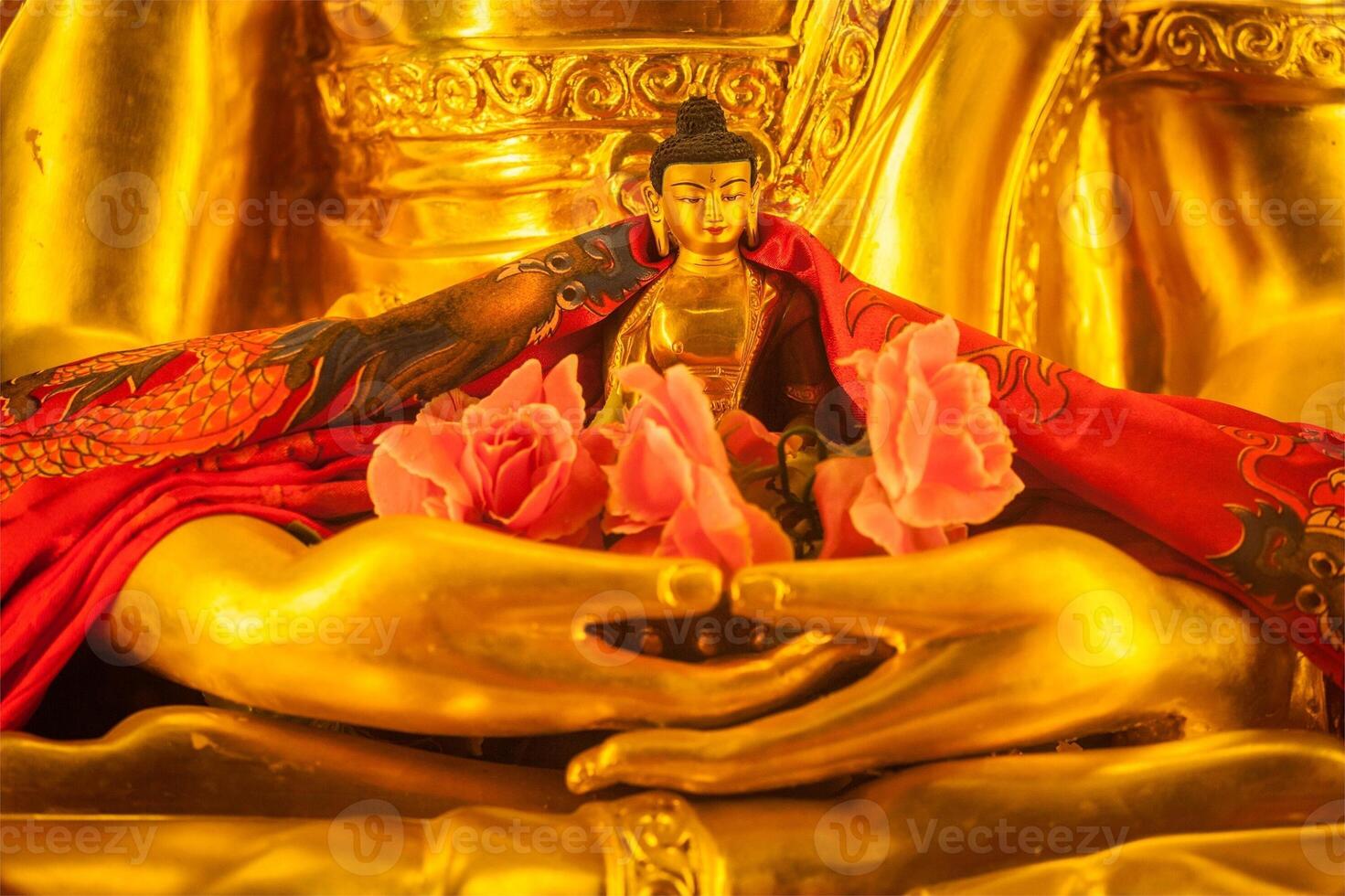 klein Boeddha sakyamuni standbeeld in handen van groot foto