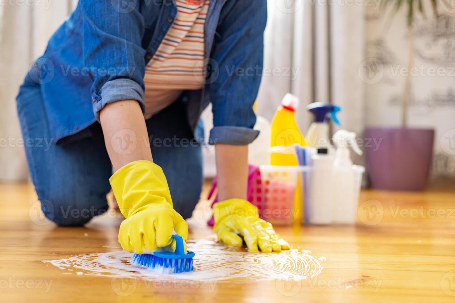 vrouw in rubber handschoenen is gebruik makend van verdieping borstel naar schoonmaak verdieping foto