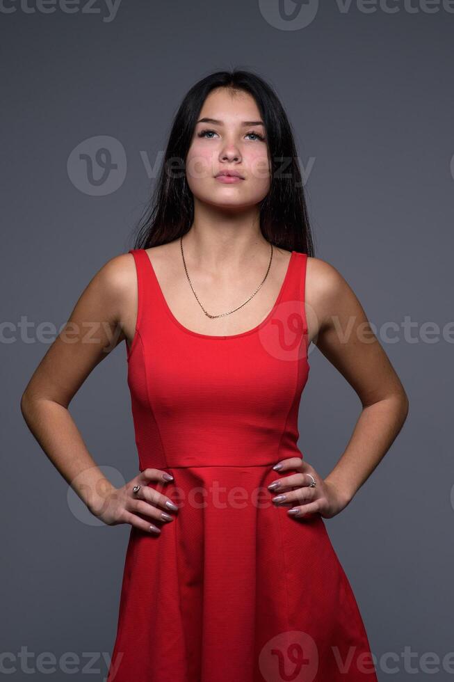 studio portret van een jong mooi meisje in een rood jurk 3 foto