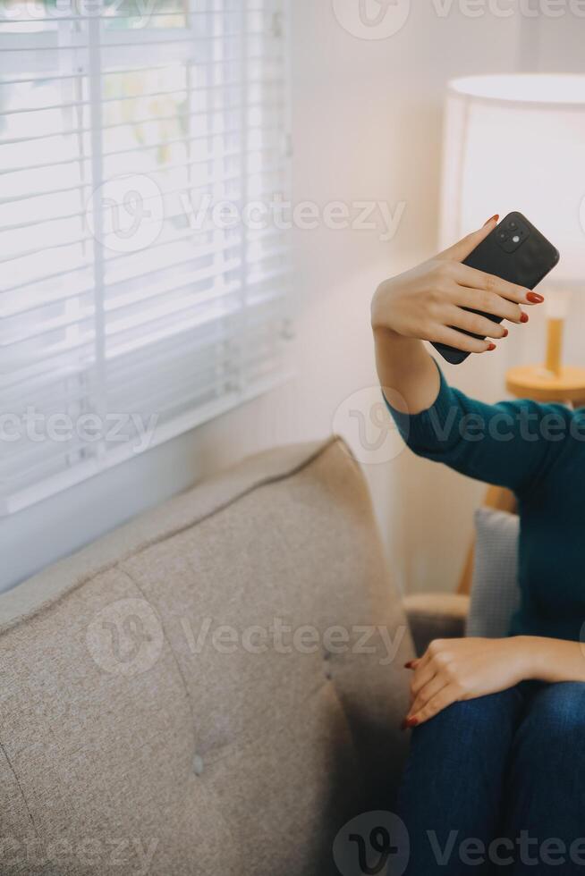 geluk ondernemer mooie zakelijke aziatische jonge vrouw draag casual gebruik mobiele telefoon om online te winkelen genieten met sociale media en laptop thuis. kleine bedrijven opstarten. online bankieren foto