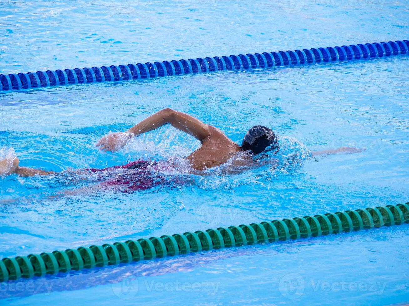 een jong Mens zwemmen in een buitenshuis zwembad. detailopname foto. concept van sport en gezondheidszorg foto