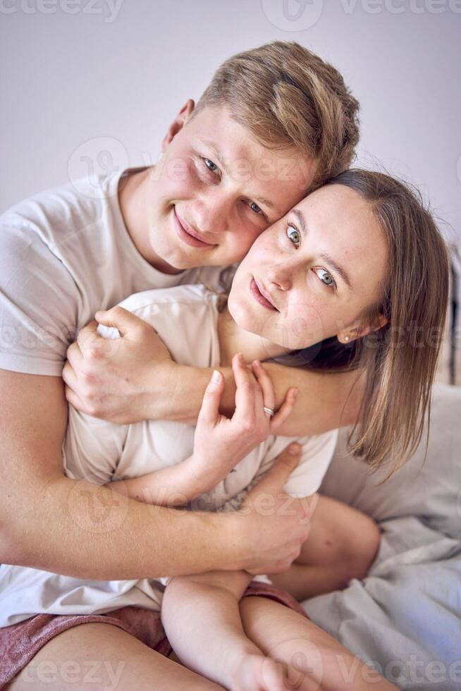 een Mens knuffels zijn vrouw van achter, gezicht naar gezicht foto