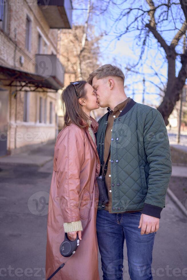 een jong paar in liefde wandelen door de voorjaar stad met een cockapoo foto