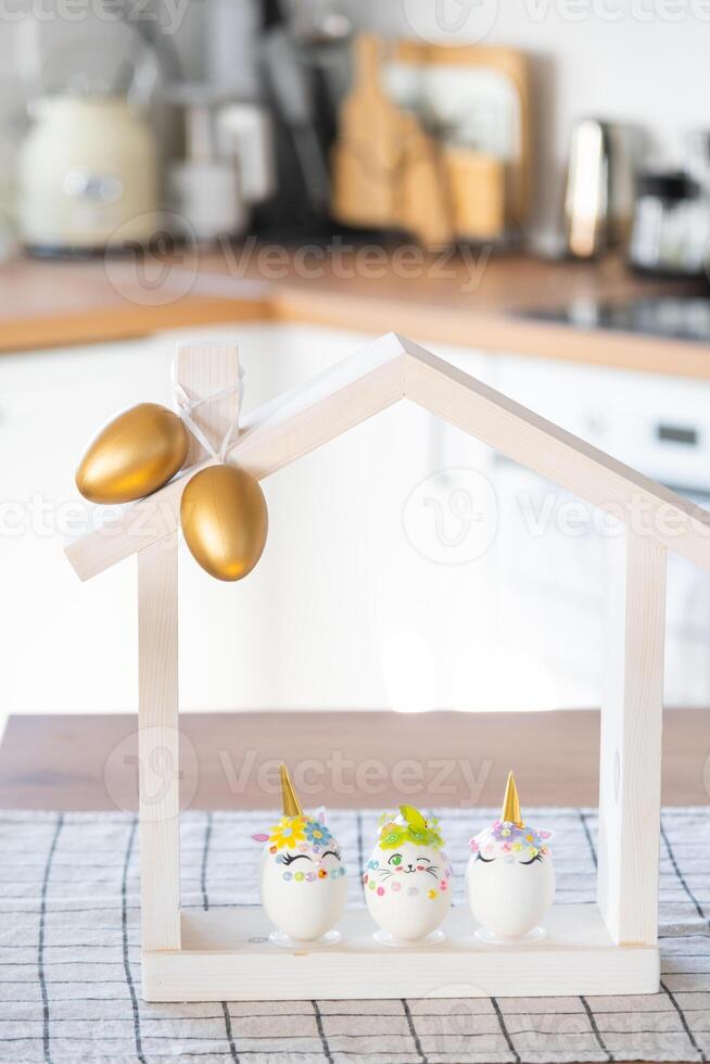 Pasen ambacht - siert een ei in de het formulier van een eenhoorn met strass steentjes, Hoorn, bloemen in de interieur van een huis foto