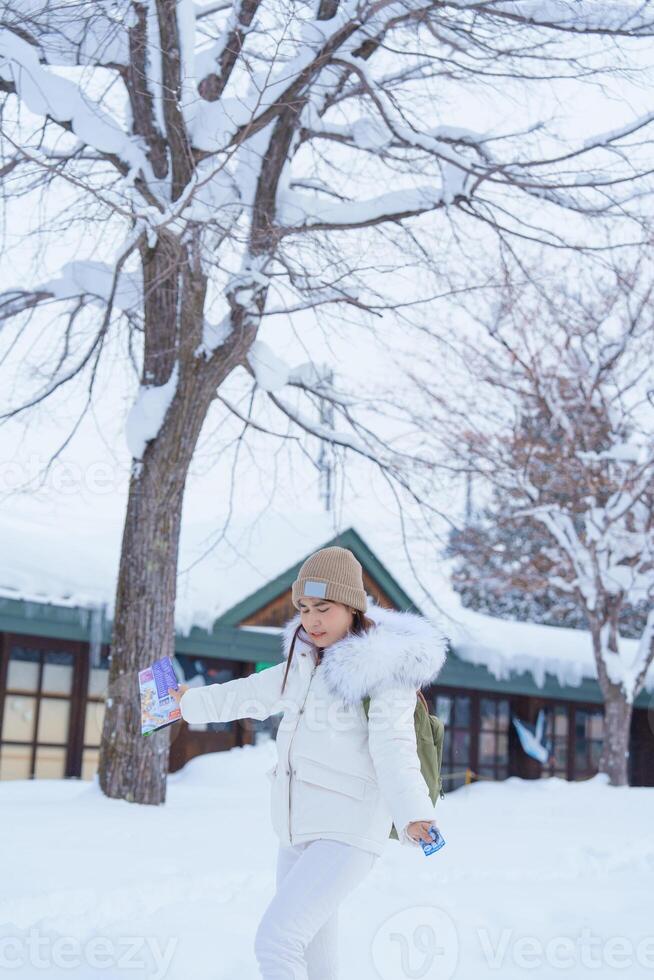 vrouw toerist bezoekende in asahikawa, reiziger in trui bezienswaardigheden bekijken asahiyama dierentuin met sneeuw in winter seizoen. mijlpaal en populair voor attracties in hokkaido, Japan. reizen en vakantie concept foto