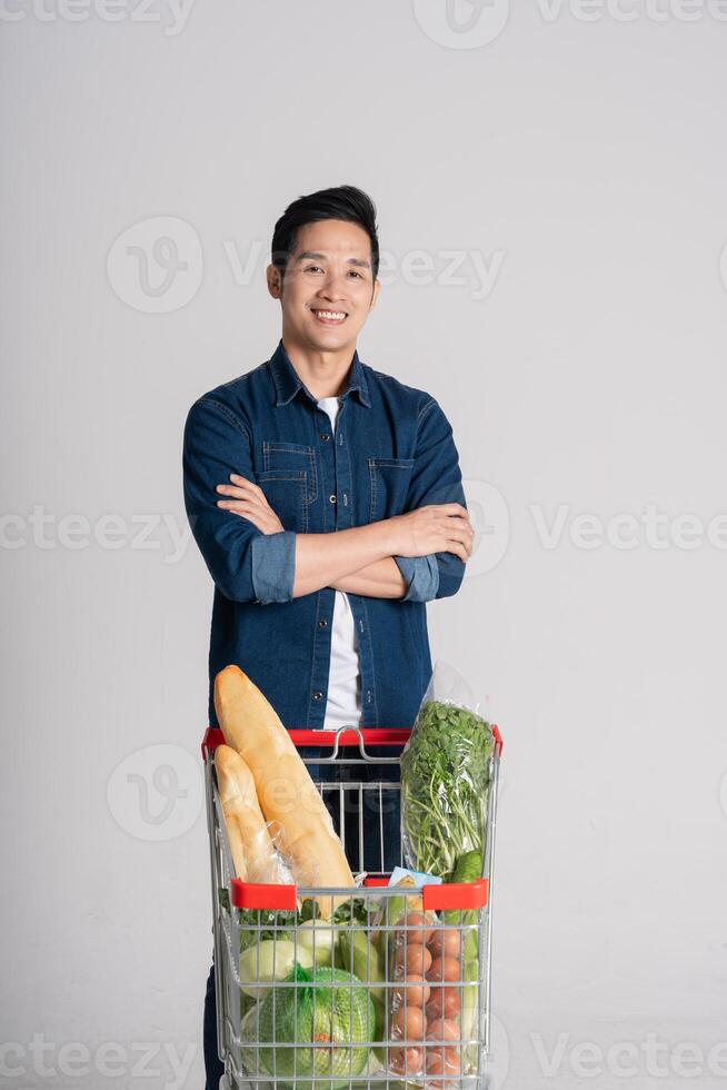 gelukkig glimlachen Mens voortvarend supermarkt kar geïsoleerd Aan wit achtergrond foto