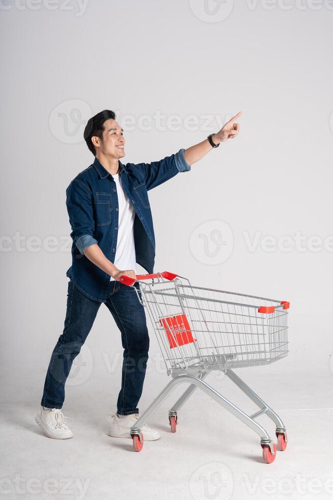 gelukkig glimlachen Mens voortvarend supermarkt kar geïsoleerd Aan wit achtergrond foto