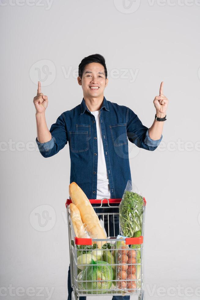 gelukkig glimlachen Mens voortvarend supermarkt kar geïsoleerd Aan wit achtergrond foto