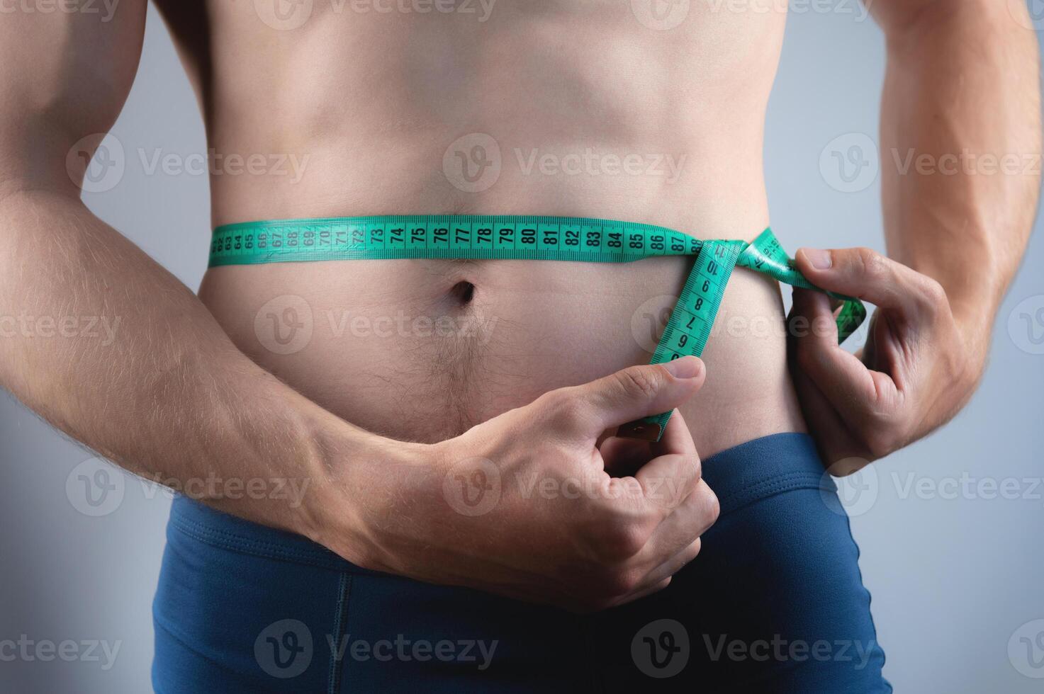 detailopname van de kaal torso en taille Oppervlakte met een meten plakband. een Mens van gemiddelde bouwen controles zijn buik grootte foto