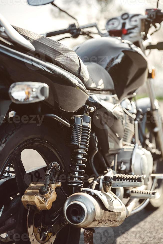 schokbreker en uitlaatpijp van zwarte motorfiets foto
