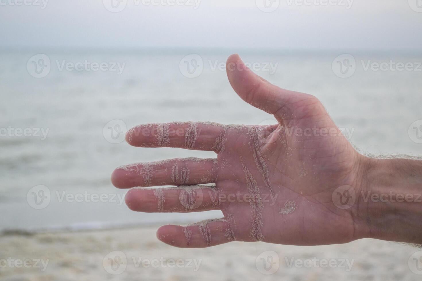 de zand is gieten van mannetje handen. foto