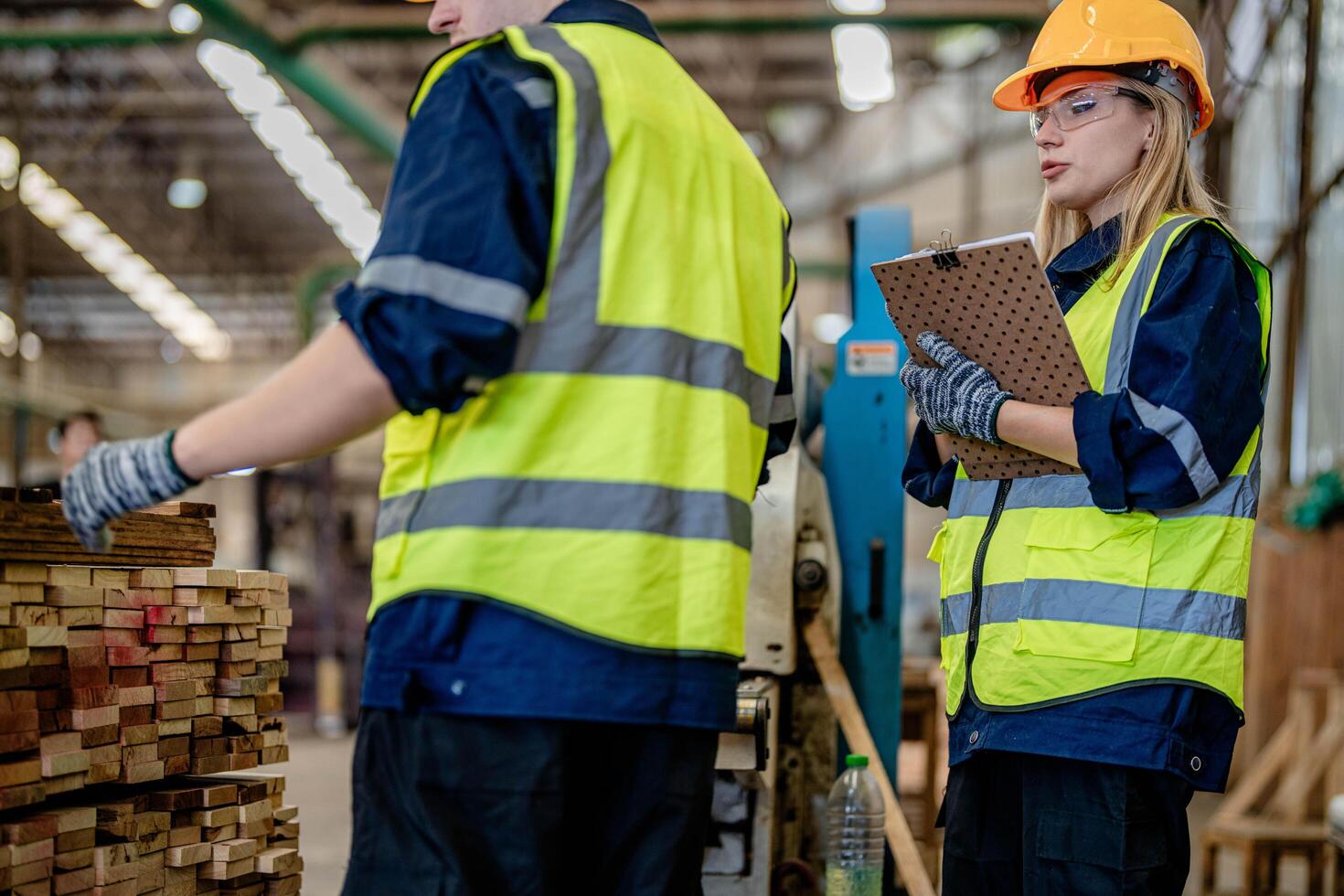 arbeider timmerlieden werken in machines naar besnoeiing hout hout. Mens en vrouw zijn bouwen met hout in een werkplaats. twee ambachtslieden of klusjesmannen werken met timmerman gereedschap of elektrisch machines. foto