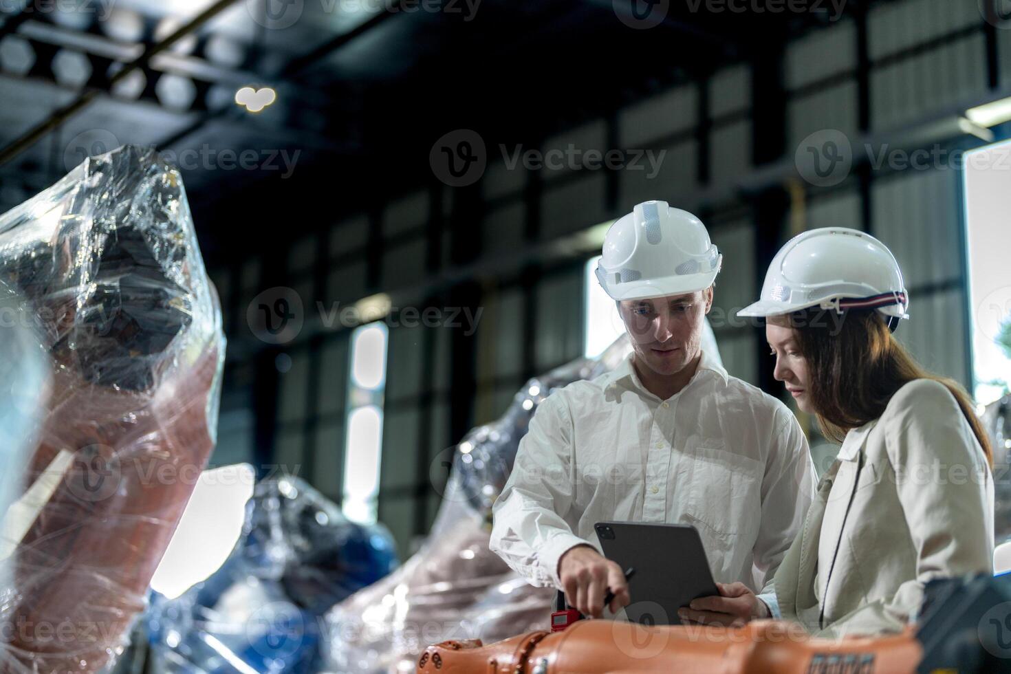 fabriek ingenieurs inspecteren Aan machine met slim tablet. arbeider werken Bij machine robot arm. de lassen machine met een afgelegen systeem in een industrieel fabriek. kunstmatig intelligentie- concept. foto