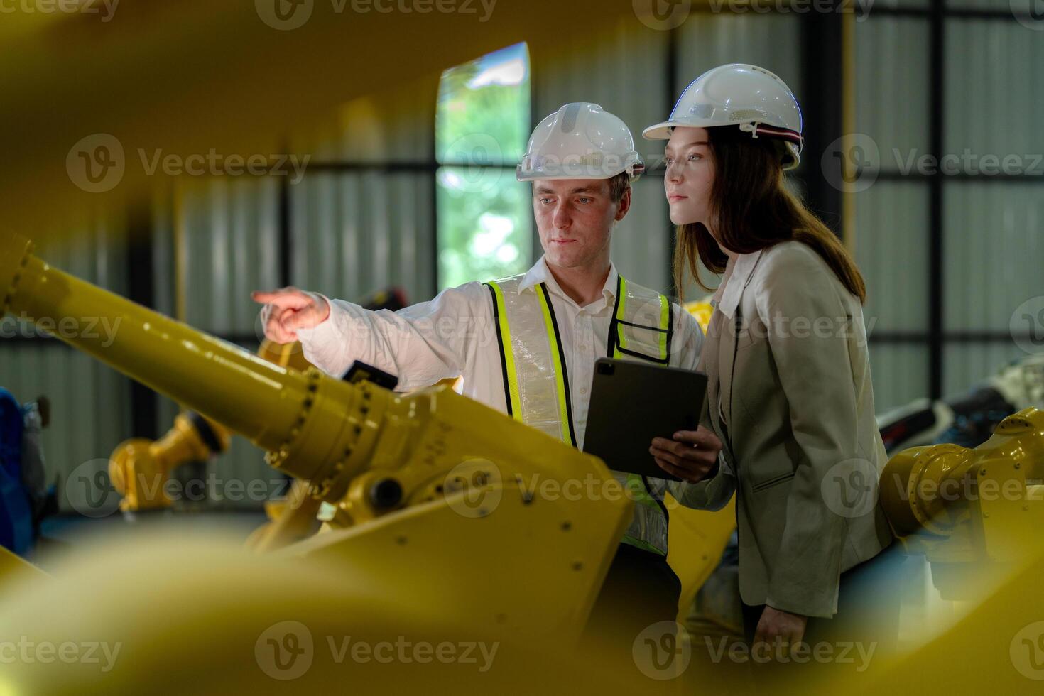 fabriek ingenieurs inspecteren Aan machine met slim tablet. arbeider werken Bij machine robot arm. de lassen machine met een afgelegen systeem in een industrieel fabriek. kunstmatig intelligentie- concept. foto