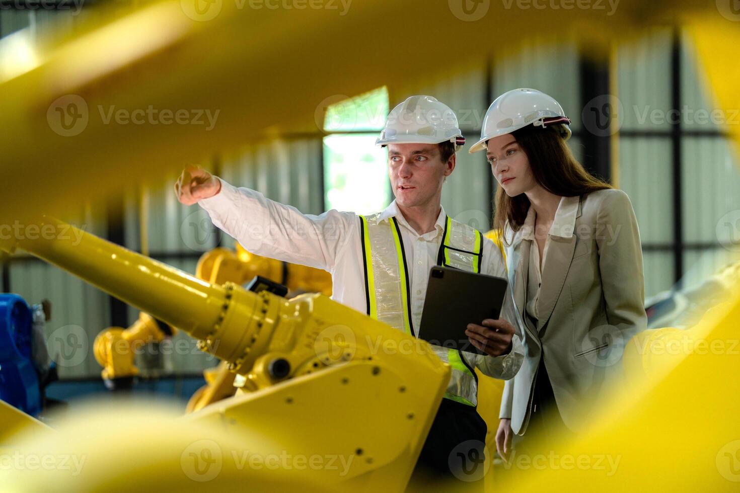 fabriek ingenieurs inspecteren Aan machine met slim tablet. arbeider werken Bij machine robot arm. de lassen machine met een afgelegen systeem in een industrieel fabriek. kunstmatig intelligentie- concept. foto